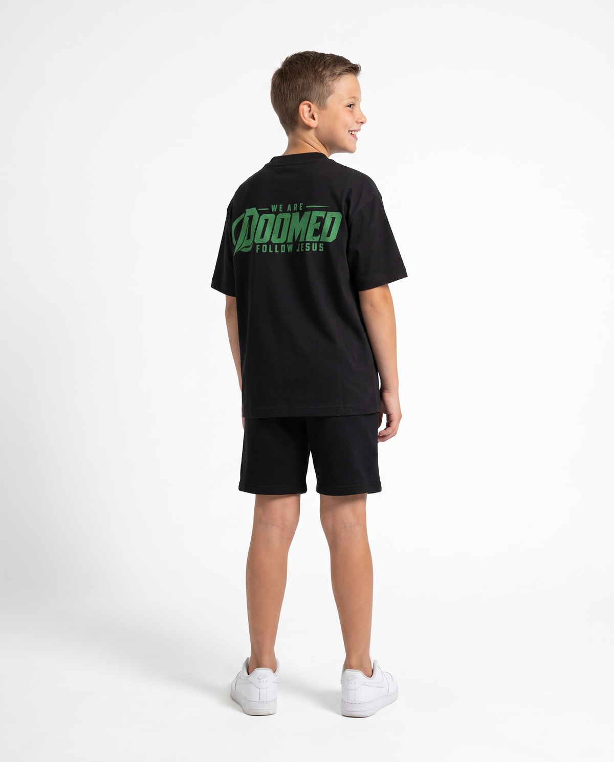 Kid wearing the Youth DOOMED Follow Jesus Tee, back print