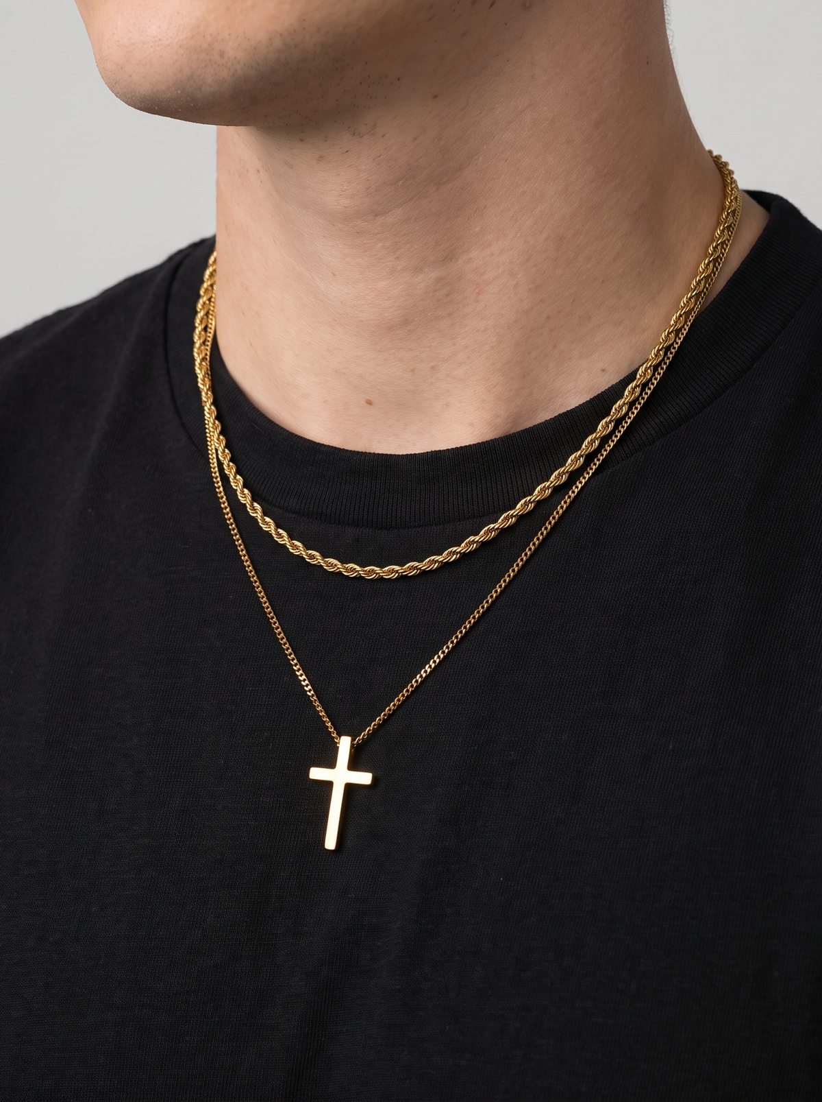 Gold cross necklace and rope chain side angle, black t-shirt