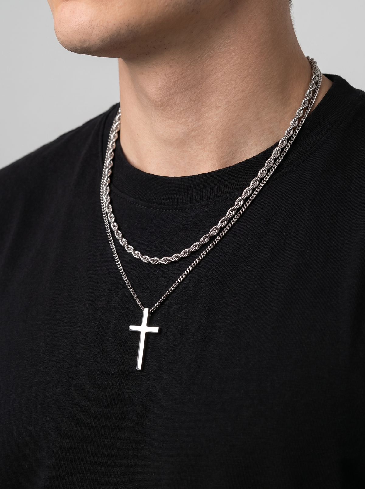 Silver cross necklace and rope chain side angle, black t-shirt