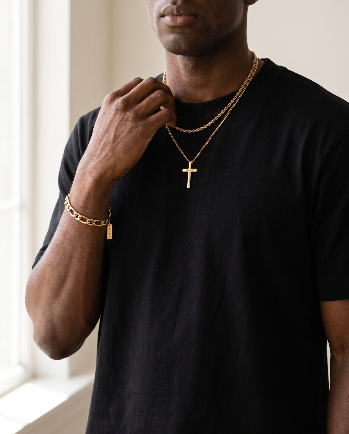 Gold rope chain and bracelet worn, hand raised